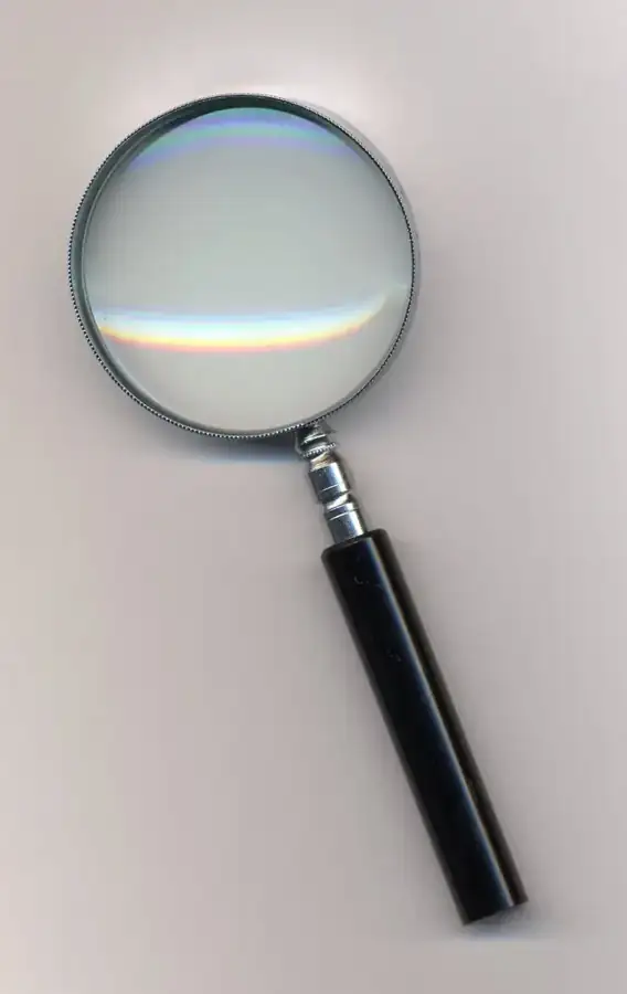 A magnifying glass on a neutral surface, illustrating careful examination